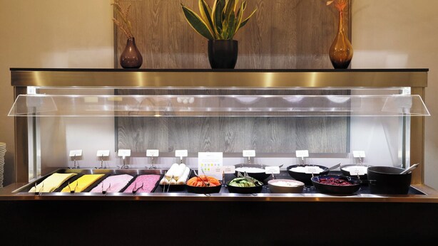A buffet with various food items and a plant in the background. - Fosshotel Barón (Reykjavik)
