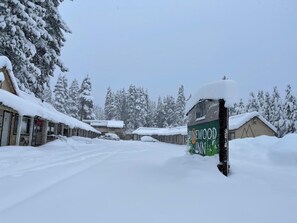 A snow-covered street with buildings, including a visible sign for Pinewood Inn. - Tahoe Sands Inn (South Lake Tahoe)