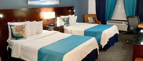A hotel room with two beds, a desk, a chair, a nightstand, a lamp, a painting of a wave, and a window with curtains.
