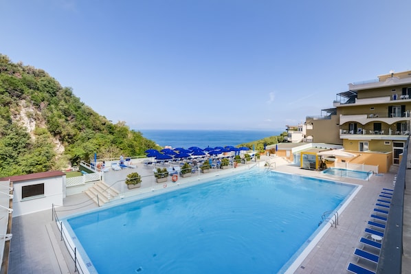 Piscine extérieure, parasols de plage, chaises longues