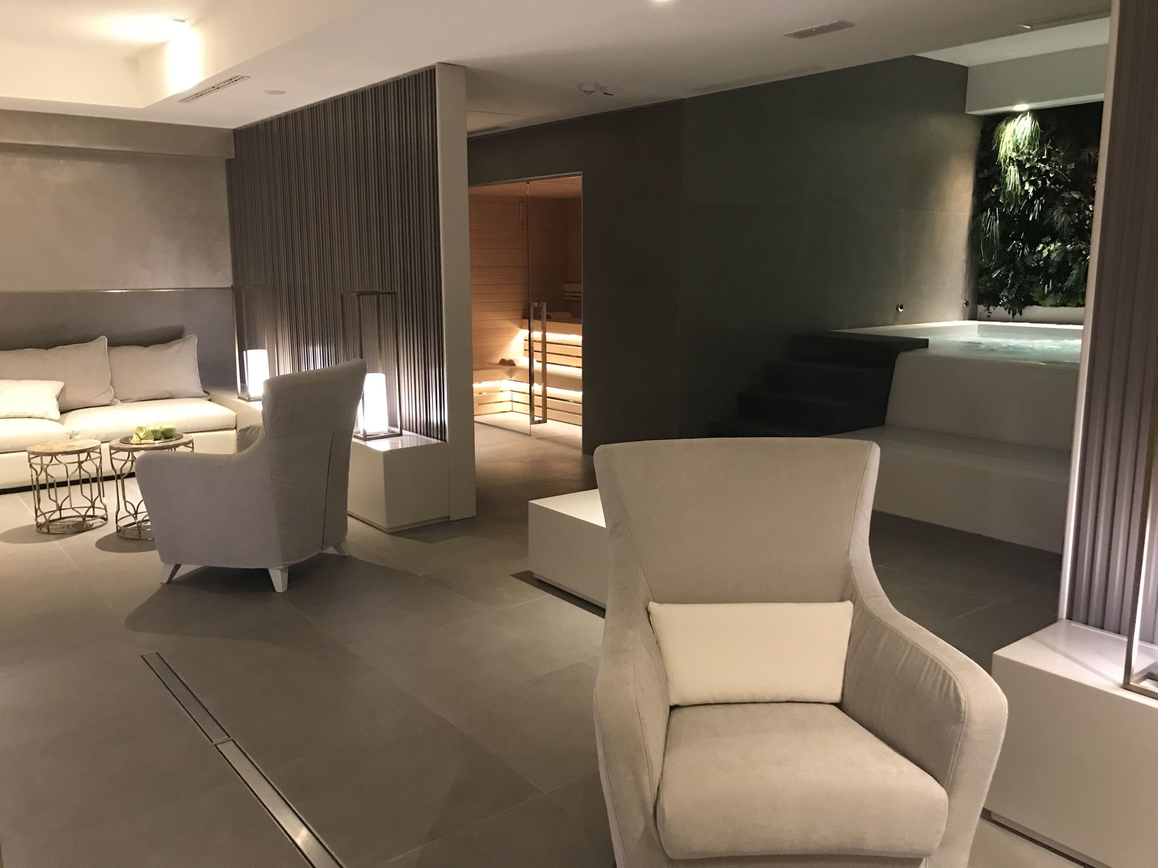 A modern living room with a sofa, armchairs, a coffee table, and a fireplace.