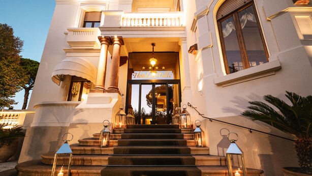 A grand entrance with a sign reading "Albermar Hotel & Spa" leading to a staircase.