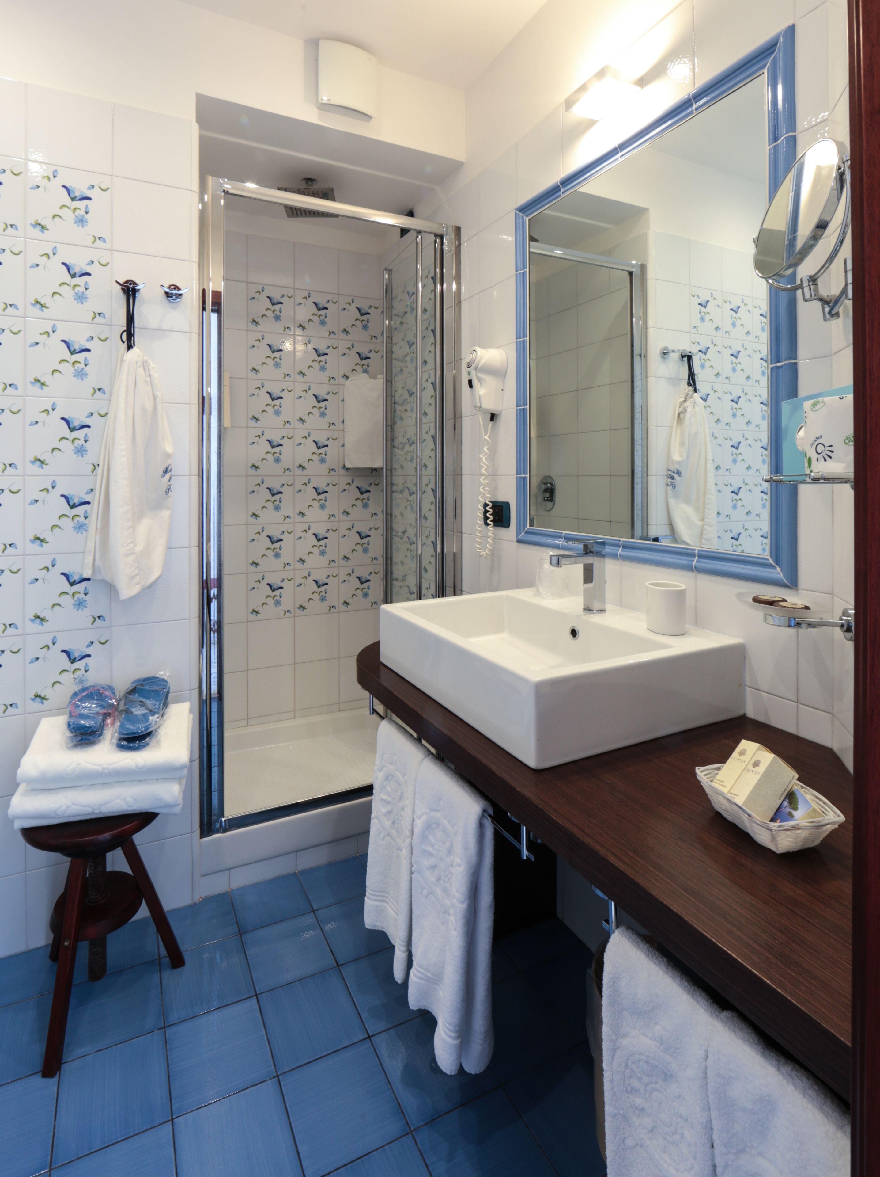 Un baño con ducha, lavamanos y espejo.