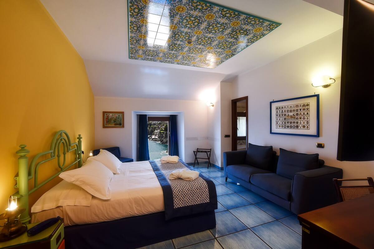 Une chambre avec un lit, un canapé, une table à manger et une vue sur une piscine.
