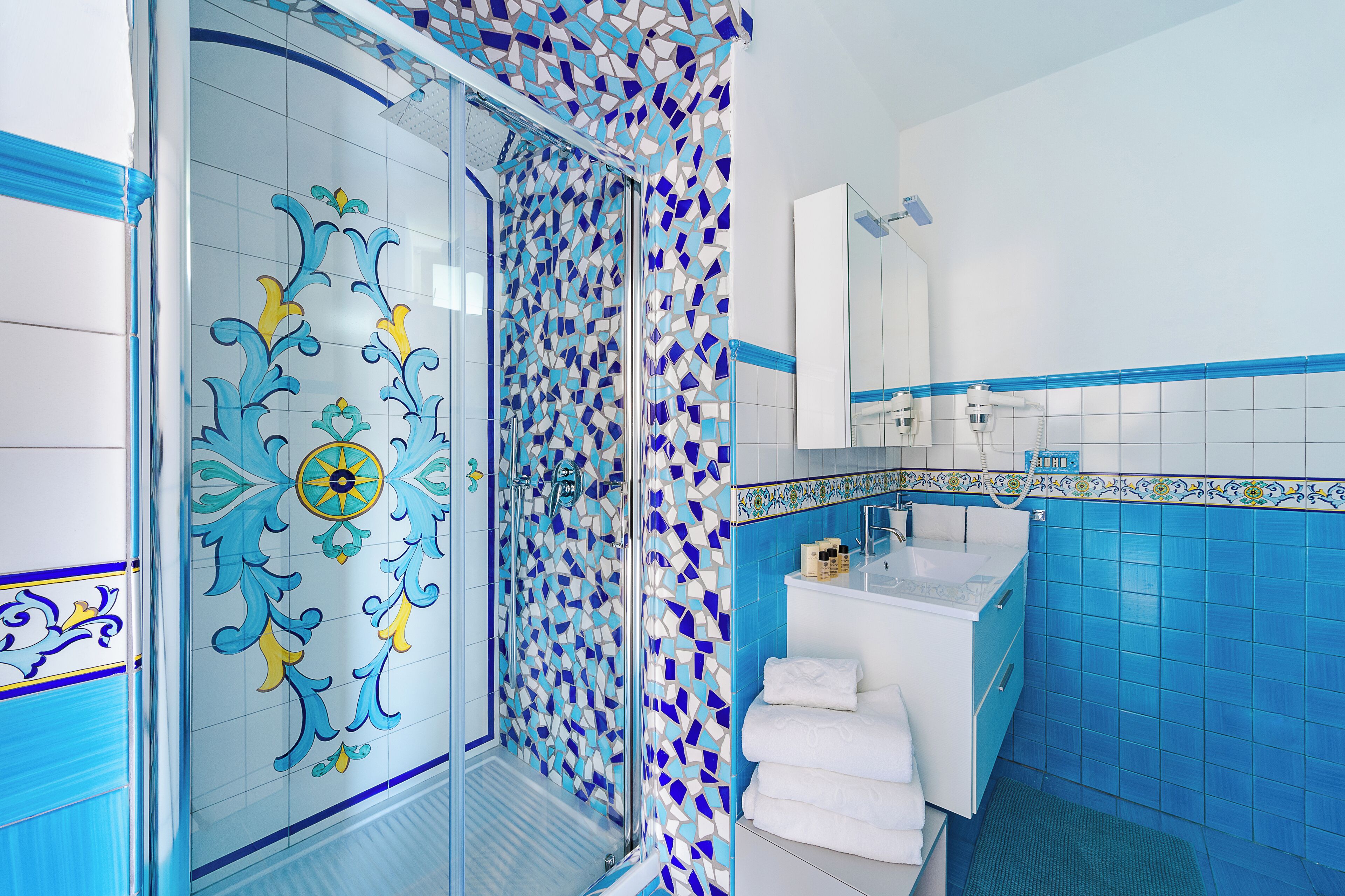 A bathroom with a shower, a sink, and a mirror.
