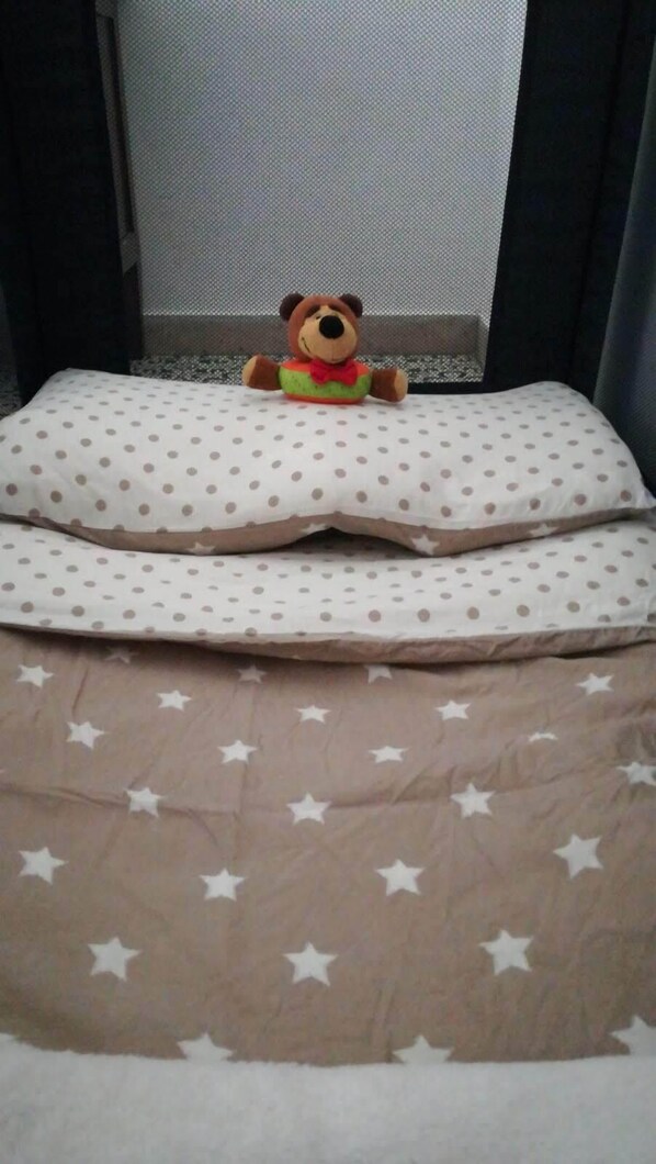 Un lit avec un oreiller à pois et une couvre-lit à motifs d’étoiles.