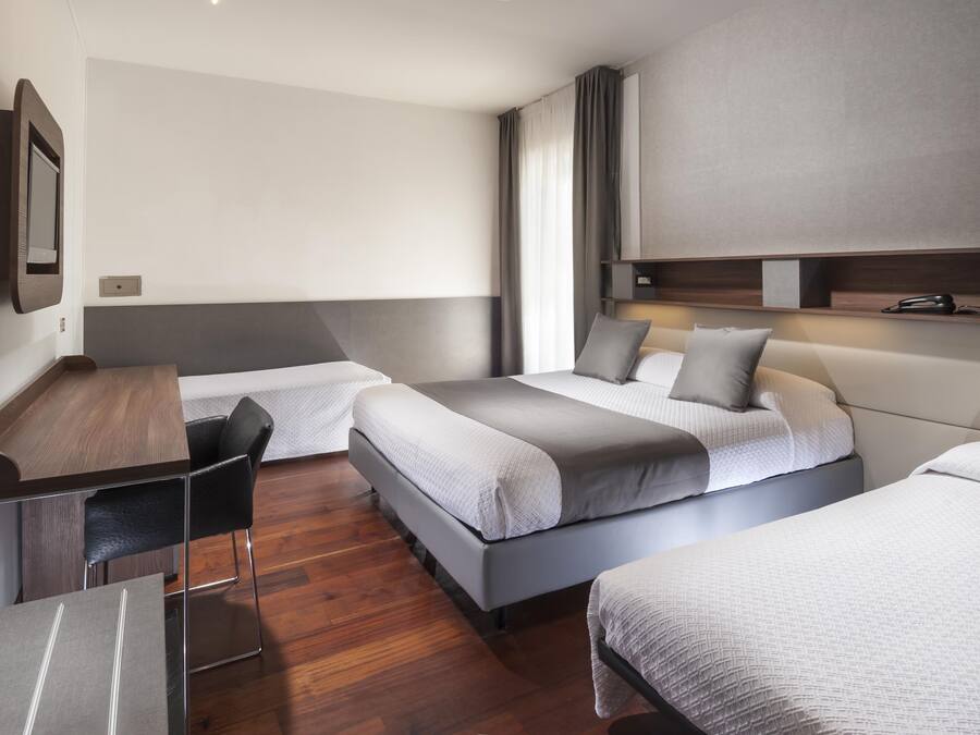 Een hotelkamer met twee bedden, een bureau en een stoel.