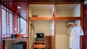 A compact hotel room with a wardrobe, a small desk, a compact heater, and a shoe rack. - Baolong Hotel Shanghai (Shanghai)