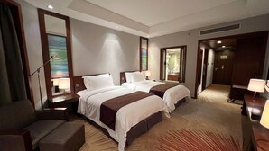 A hotel room with two beds, a sofa, a desk, a mirror, and a carpeted floor. - Baolong Hotel Shanghai (Shanghai)