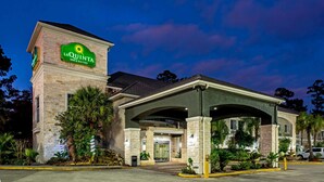 Edificio de La Quinta Inn & Suites con fachada de piedra, entrada cubierta y cartel.