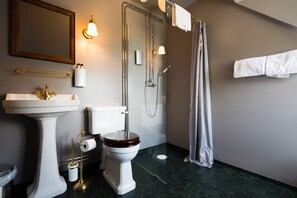 Un baño con lavamanos pedestal, inodoro y ducha.