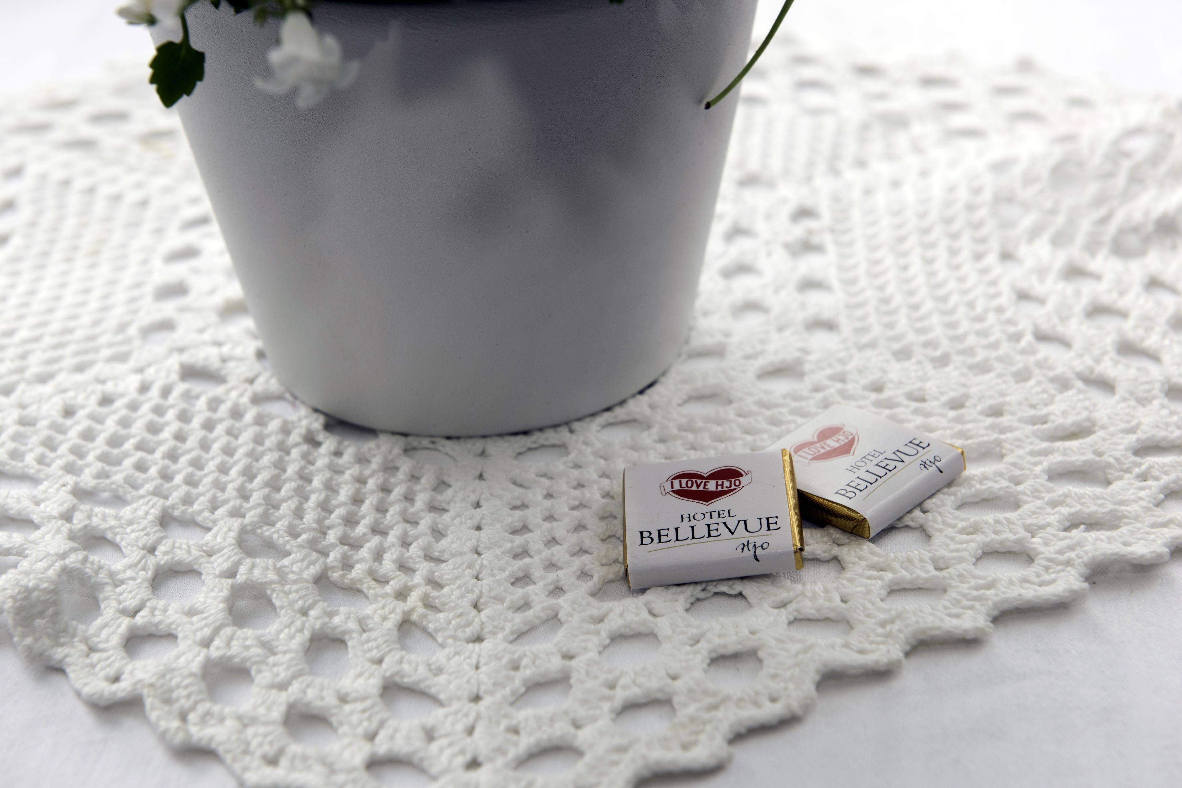 A white doily with a small white box labeled "I Love HJ Hotel Bellevue" on it.