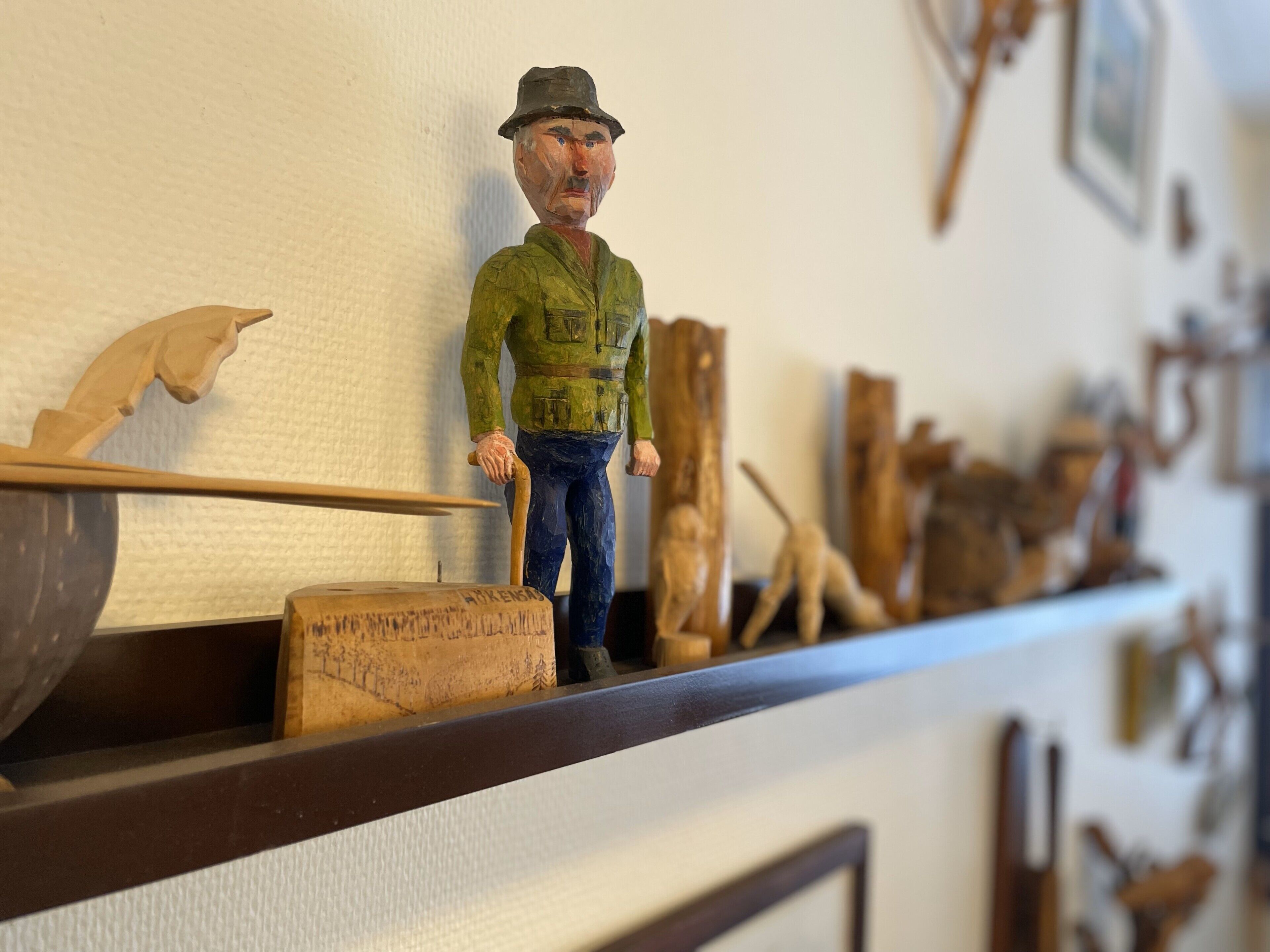 Un estante de madera con varias herramientas y una figurita.