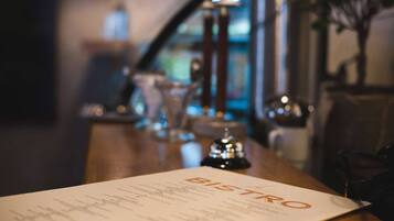 A menu titled "BISTRO" on a table in a dimly lit restaurant setting.