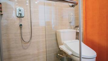 A modern bathroom with a glass-enclosed shower, a white toilet, and a stainless steel sink.