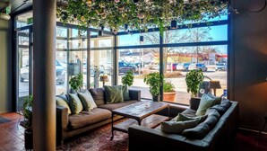A modern interior with a sectional sofa, a wooden coffee table, and potted plants.