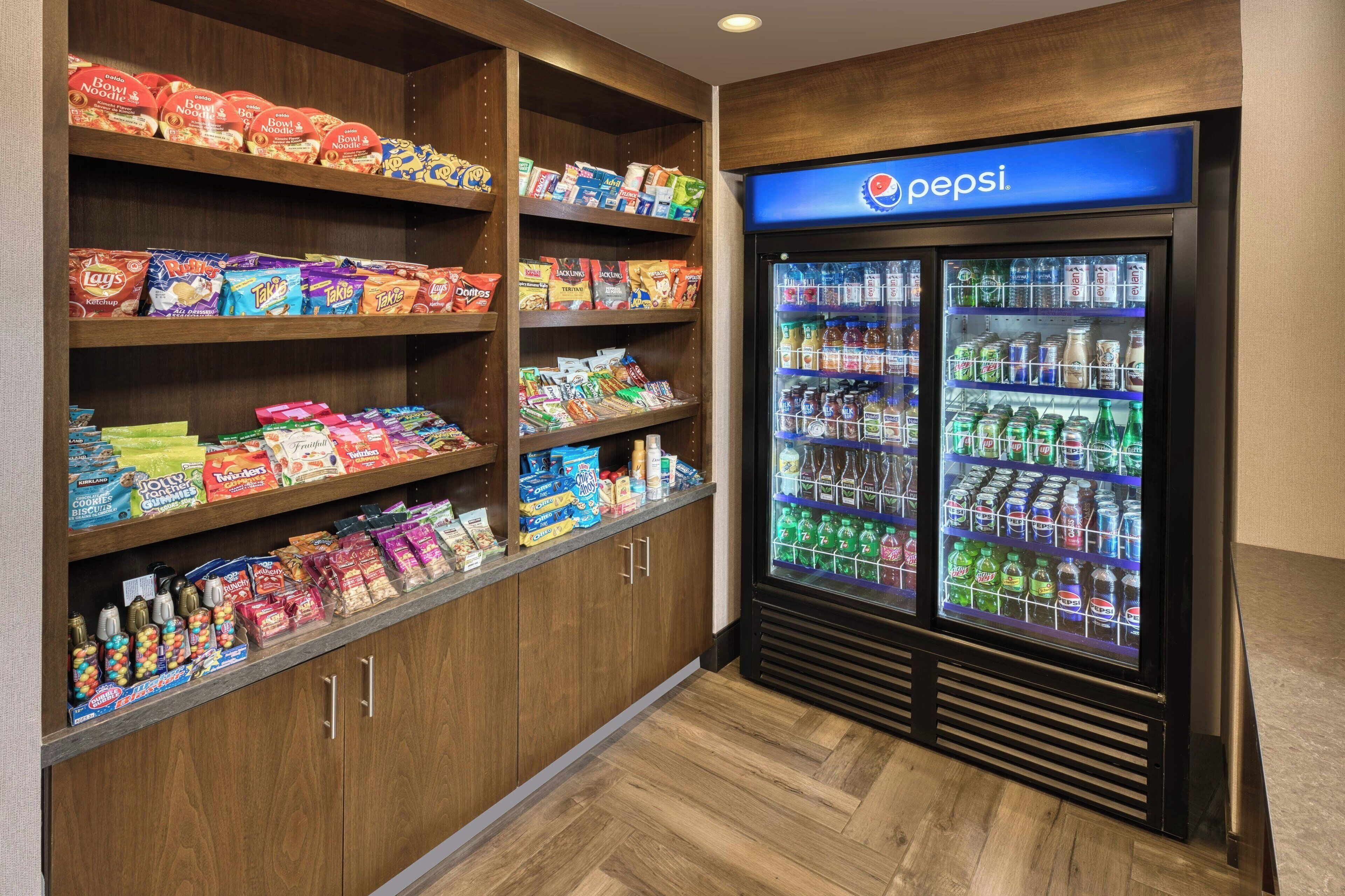 A snack and beverage area with shelves stocked with various snacks and a Pepsi refrigerator.