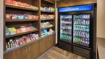 A snack and beverage area with shelves stocked with various snacks and a Pepsi refrigerator.