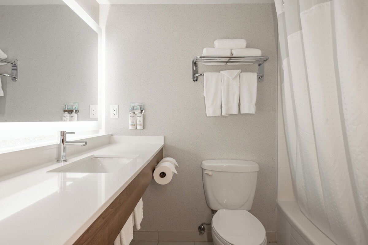 A bathroom with a sink, toilet, and towel rack.