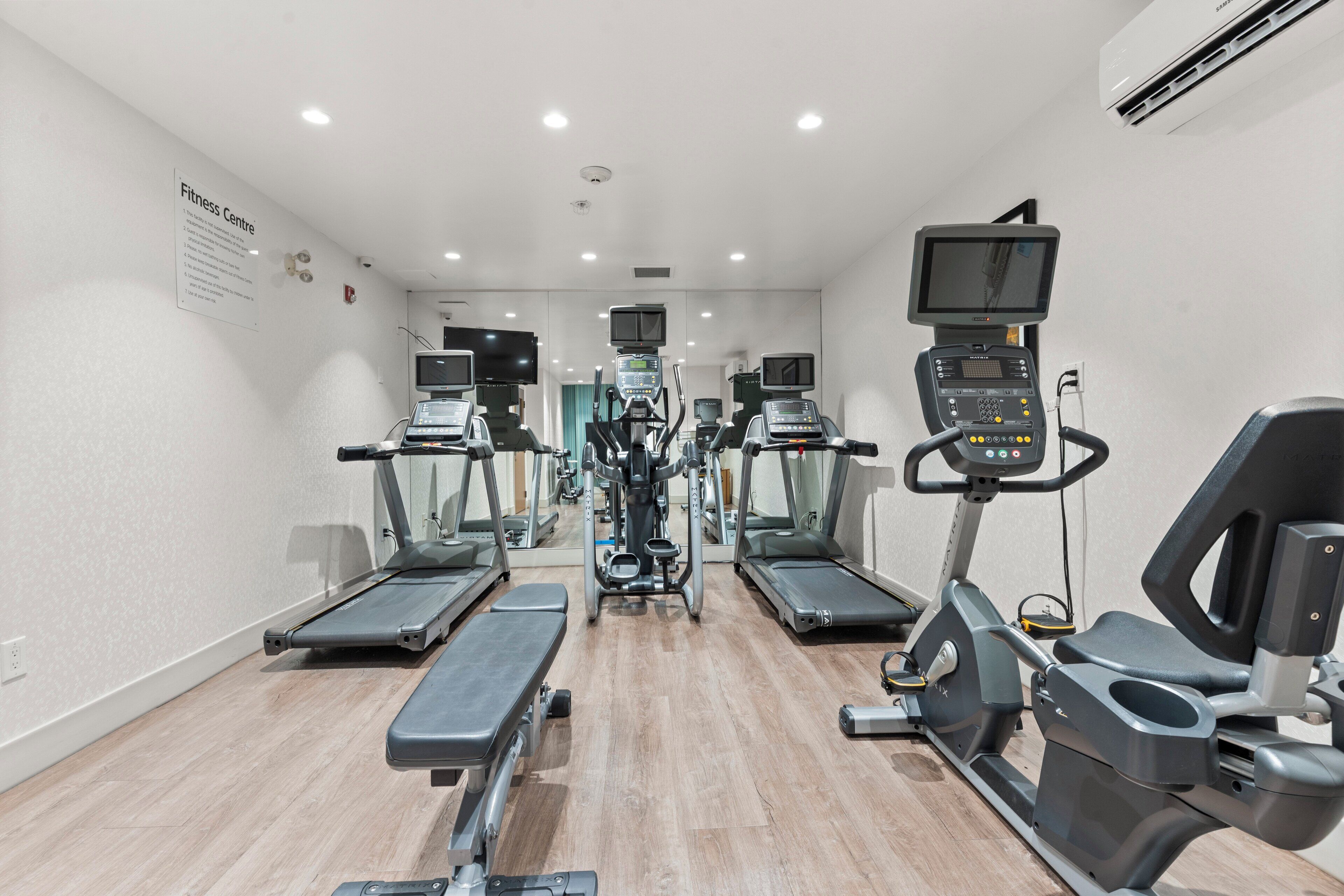 A fitness center with treadmills, elliptical machines, and weight machines.
