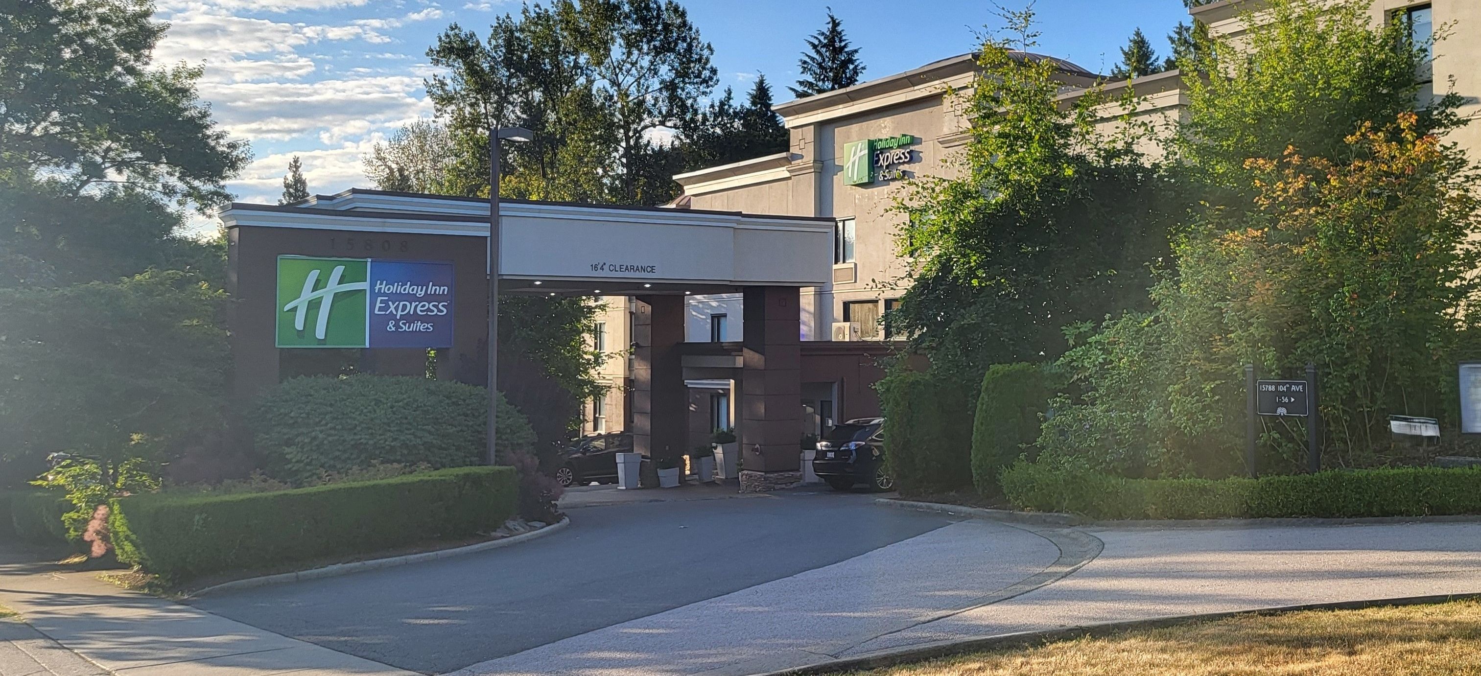 A Holiday Inn Express & Suites building with a 164 clearance sign.