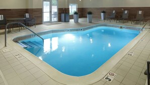A swimming pool with a tiled deck, lounge chairs, and a small seating area with tables. - Fairfield Inn & Suites by Marriott Frankfort (Frankfort)