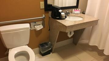 A standard hotel bathroom with a toilet, sink, and hand dryer.