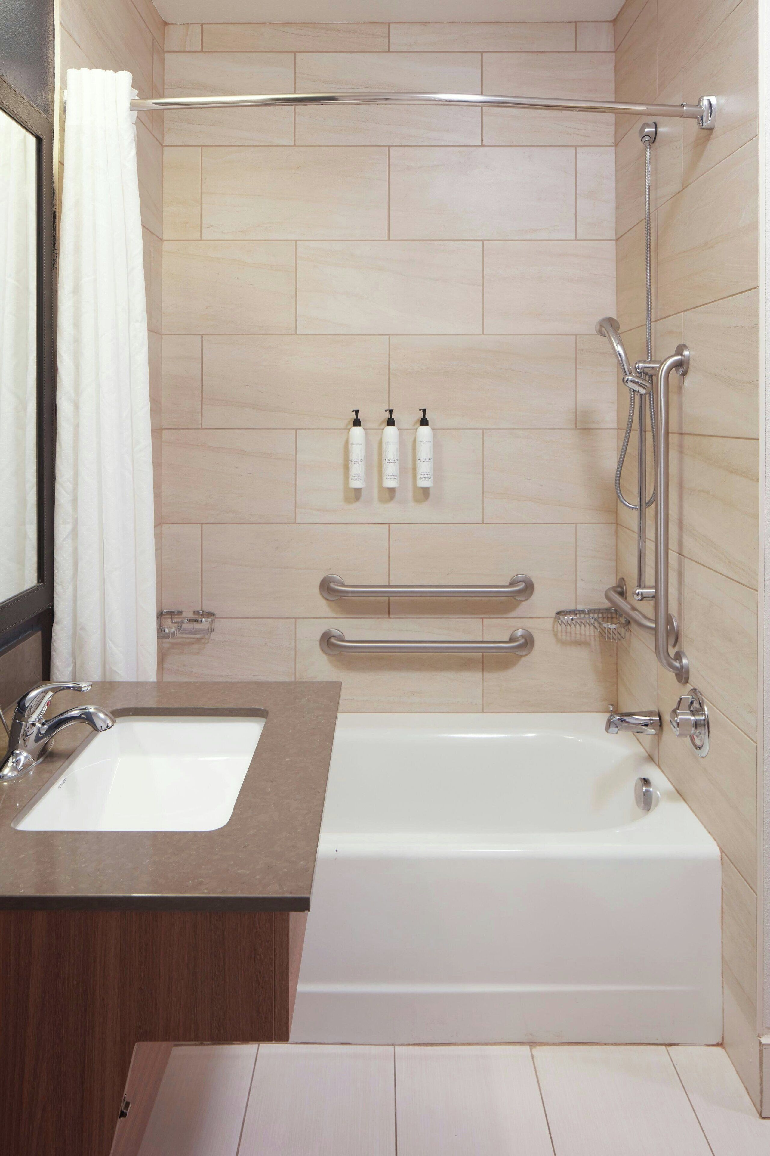 Un baño moderno con bañera, lavabo y zona de ducha.