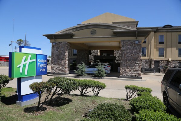 A hotel entrance with a sign for Holiday Inn Express & Suites, stone pillars, and a parking area. - Holiday Inn Express Hotel & Suites Cleveland by IHG (Cleveland)