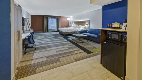 A hotel room with a bed, a sofa, a desk, and a kitchenette. - Holiday Inn Express & Suites London by IHG (London)
