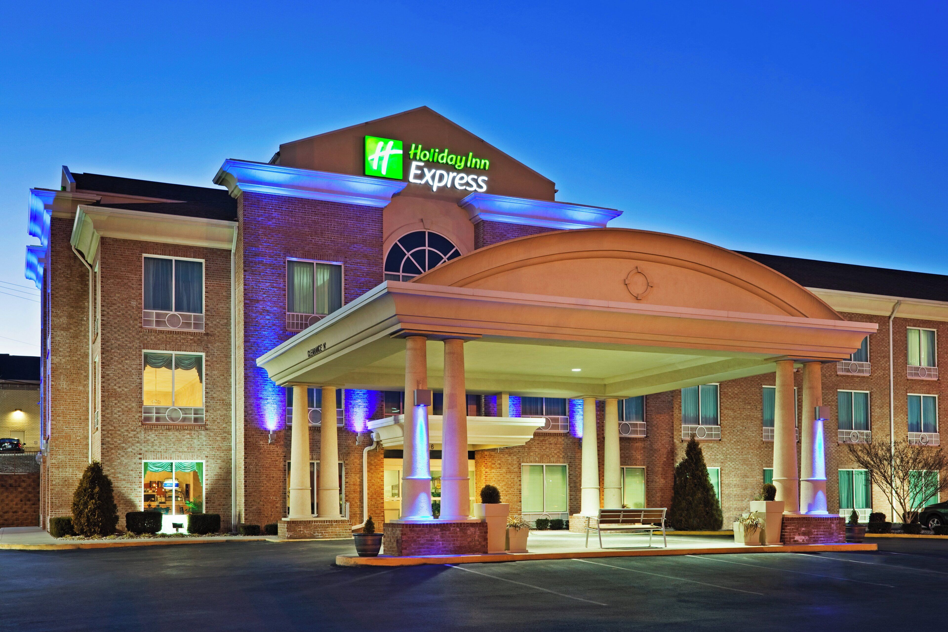 A Holiday Inn Express hotel with a covered entrance, brick facade, and a sign indicating the brand.