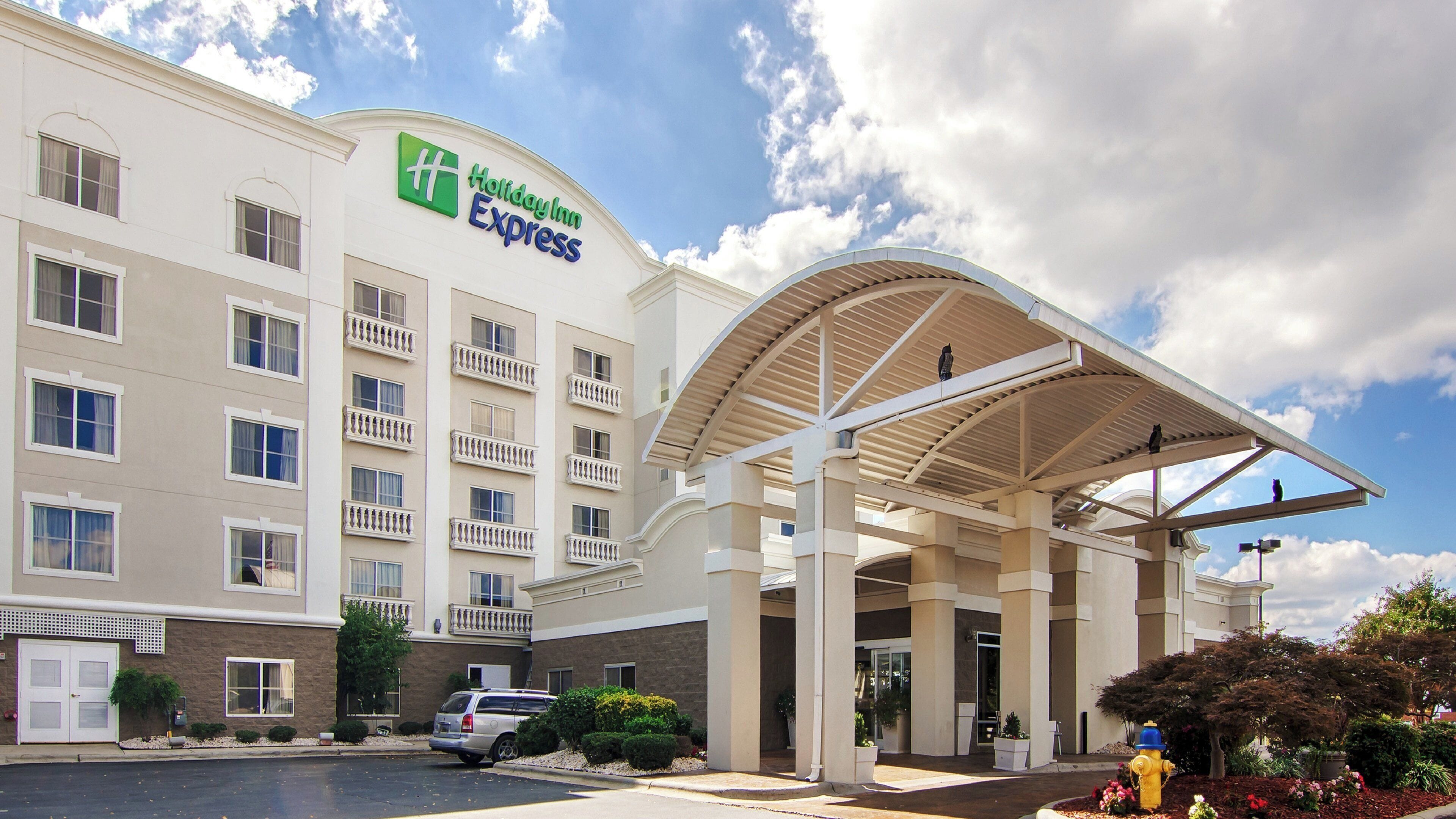 Un bâtiment de l’hôtel Holiday Inn Express doté d’une entrée couverte et de plusieurs balcons.
