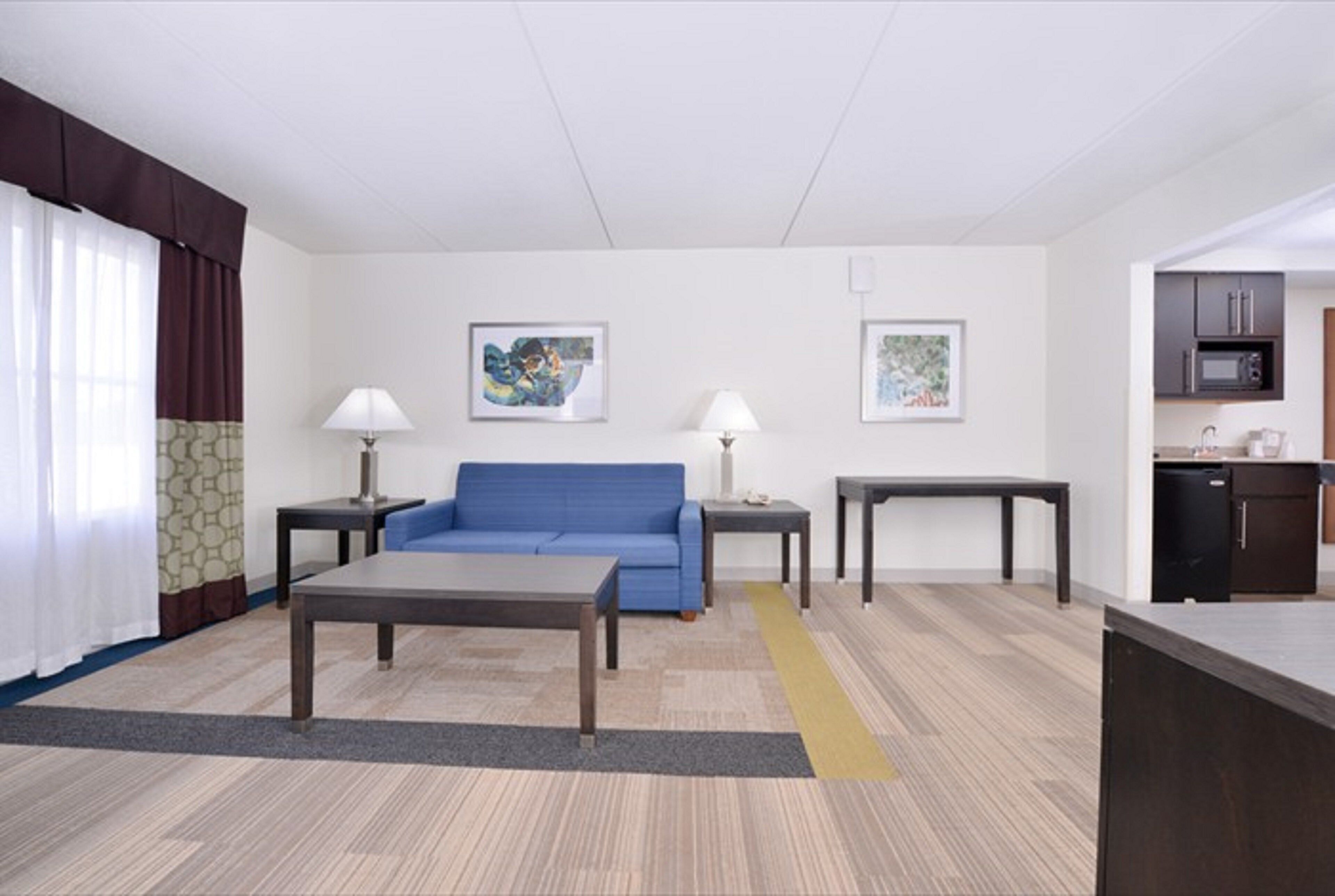 A modern living room with a sofa, two tables, and artwork on the walls.