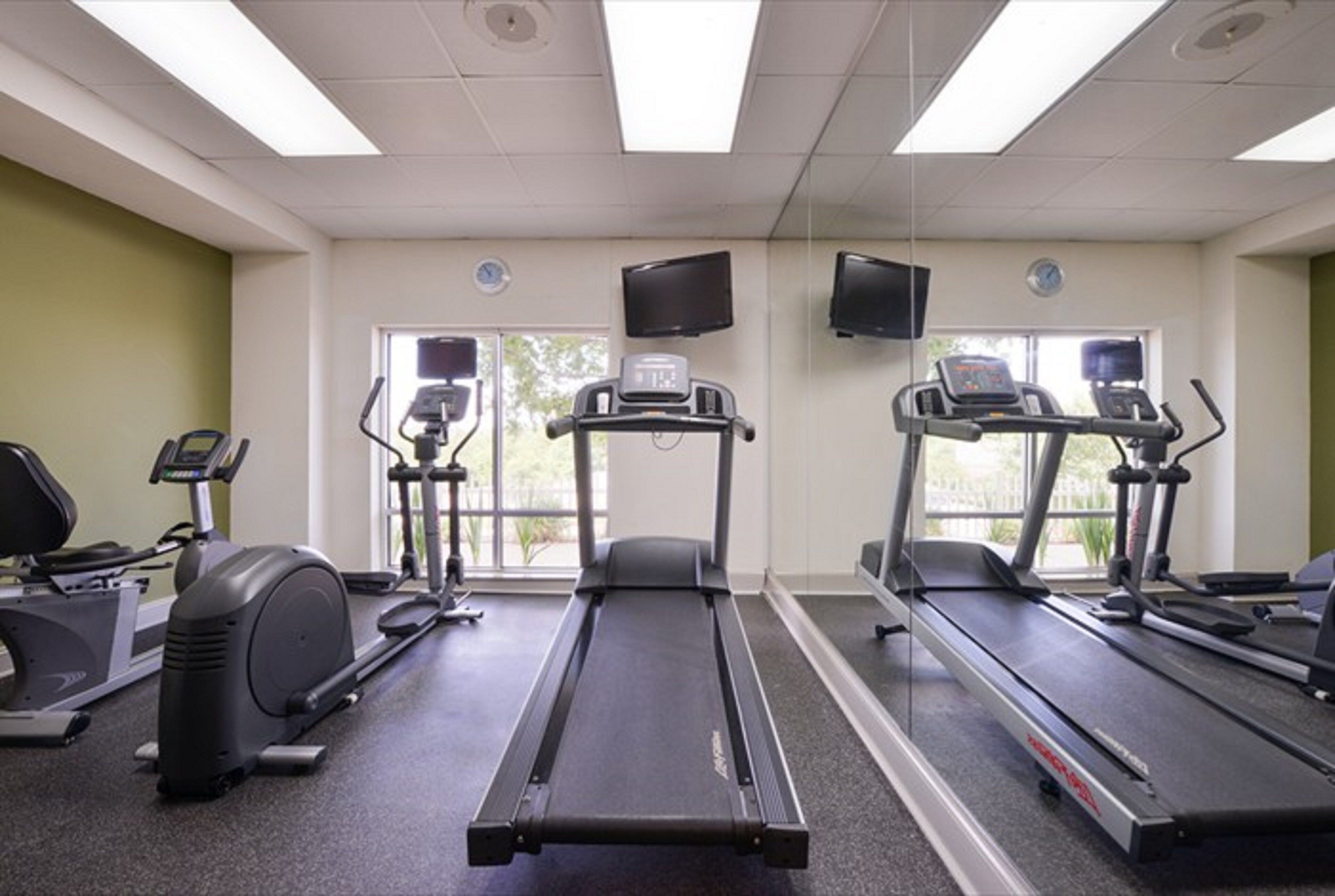 A gym with treadmills, an elliptical, and a stationary bike.