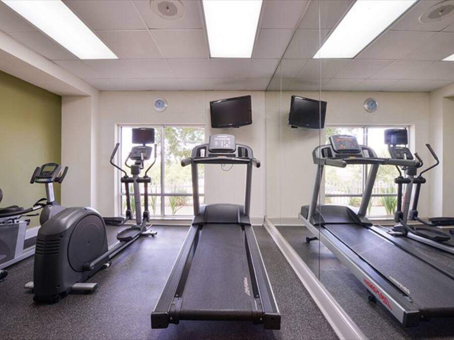A gym with treadmills, an elliptical, and a stationary bike.