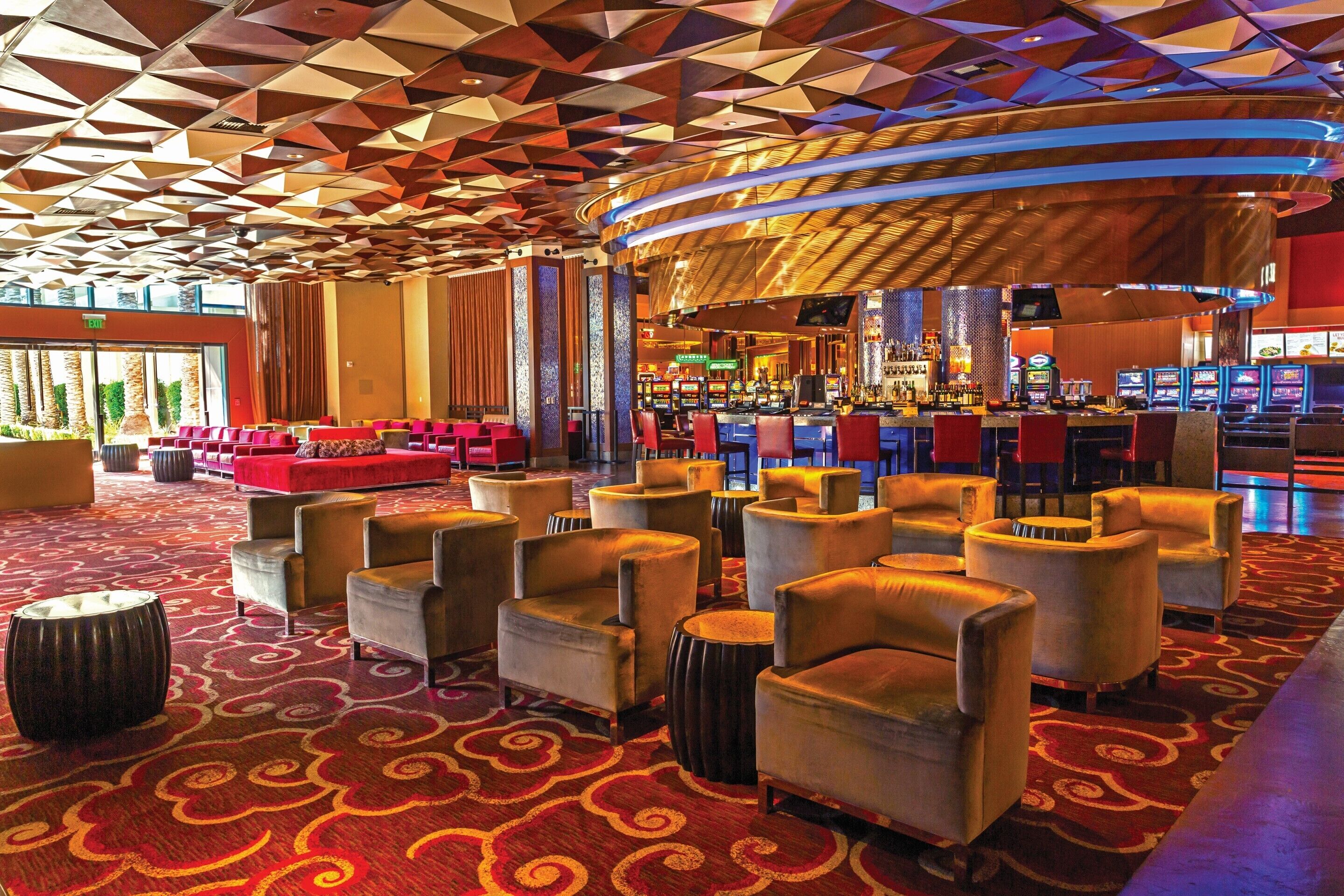 A hotel lobby with a bar area, seating arrangements, and a patterned carpet.