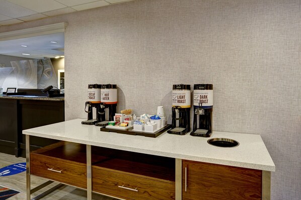 A coffee station with four coffee dispensers labeled 'Decaf Roast', 'Hot Water', 'Light Roast', and 'Dark Roast'.