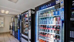Une rangée de distributeurs automatiques proposant une variété de boissons et d’en-cas.