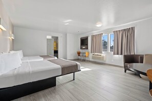 A hotel room with two beds, a dining area, a TV, and a window with curtains. - Motel 6 Sunnyvale, CA - North (Sunnyvale)