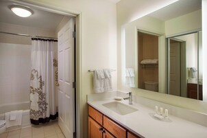 Un baño con ducha, inodoro, lavabo y espejo.