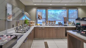 A modern kitchen with a central island, stainless steel appliances, and a view of the outdoors through large windows. - Residence Inn by Marriott Detroit Novi (Novi)