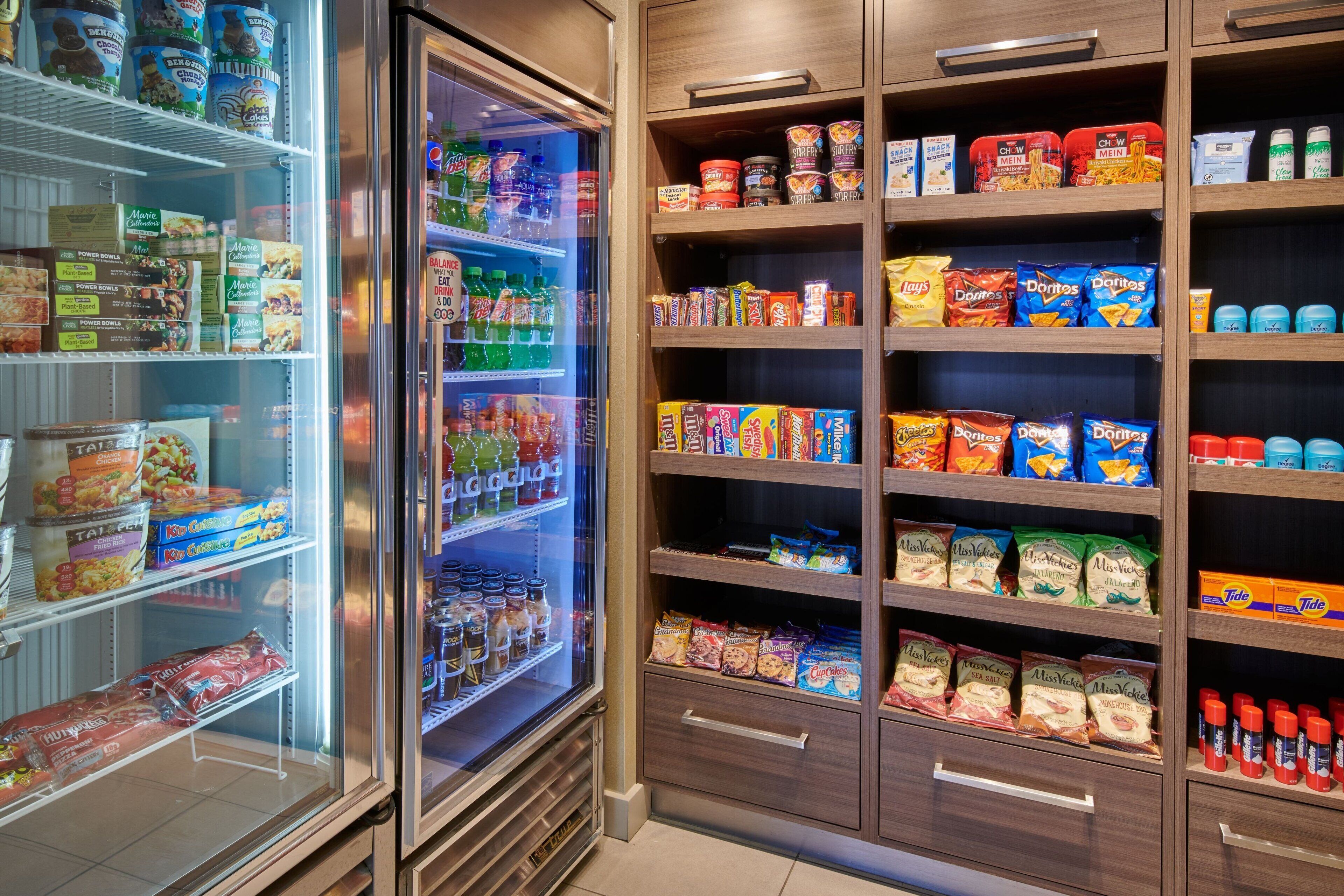 A refrigerated section with various food items and a pantry stocked with snacks and condiments.