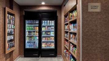 Ein Eckladen mit Getränkekühlschränken und Regalen voller Snacks und Erfrischungsgetränke.