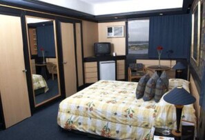 Relax in this cozy space with a comfortable bed, bedside table, and TV.