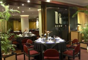 Formal dining area with elegant tables and comfortable seating, perfect for business meetings or special occasions.