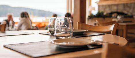 A dining table with a clear view of a mountain landscape through a window.