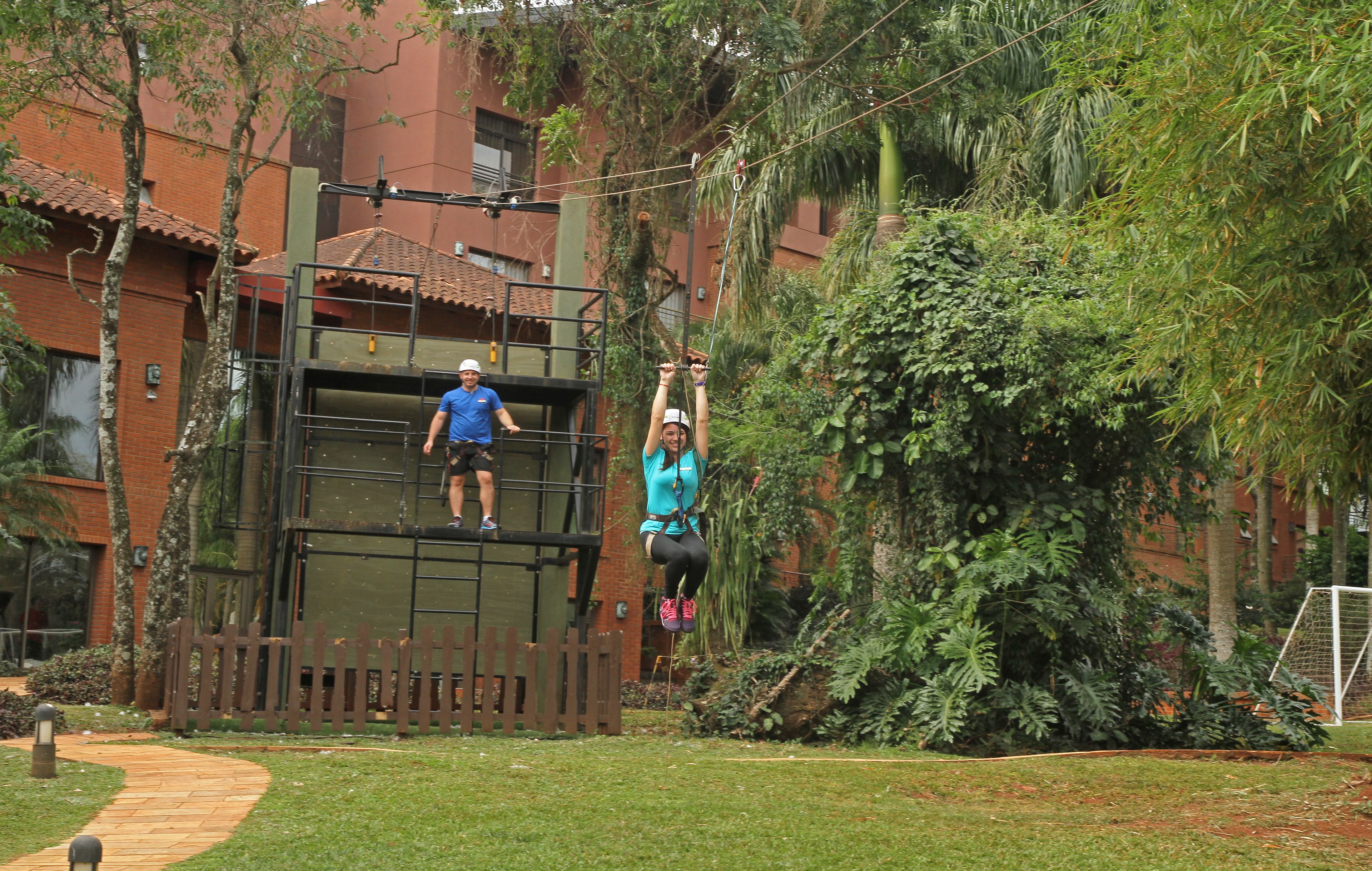 A zip line activity with participants in a lush, green environment.