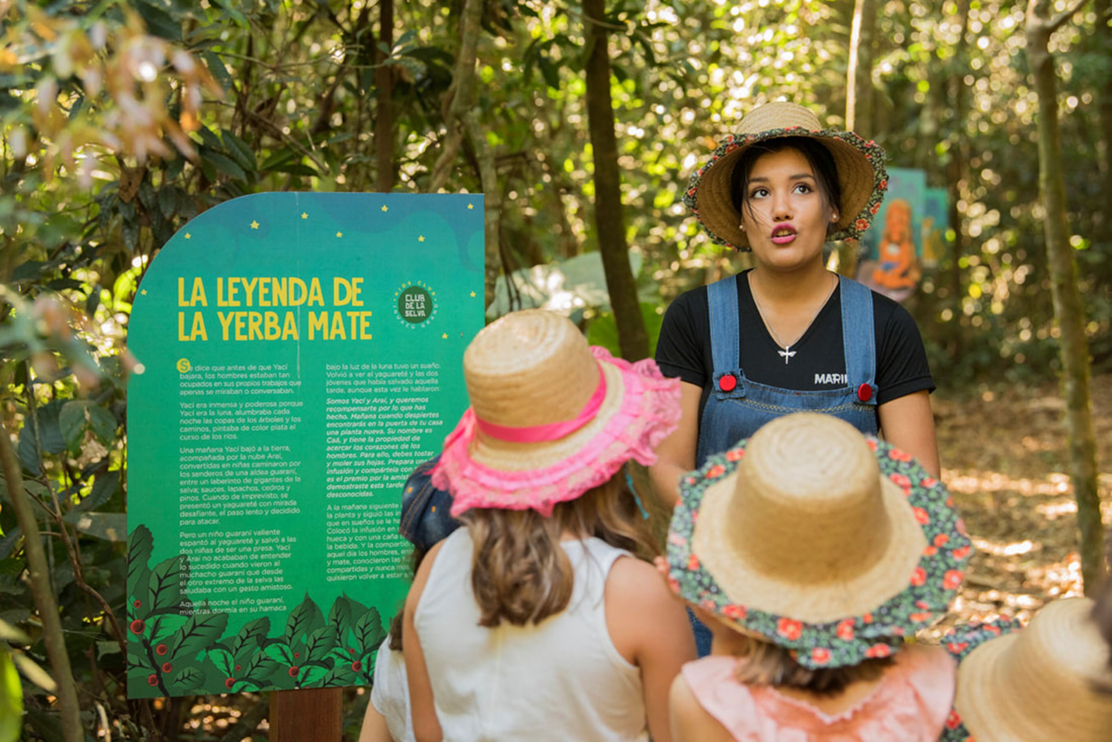 A sign with text in Spanish, surrounded by greenery.