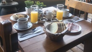 Une table de petit-déjeuner avec des assiettes remplies de nourriture, des tasses de café et des verres de jus d’orange.