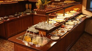 A buffet with various food items and beverages, including a fruit bowl, sandwiches, and a juice station. - Hotel Remanso (Punta del Este)